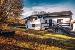 a white house with a staircase next to a yard at NEU Ferienhaus Paditz mit Pool in Oberscheibe