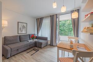 a living room with a couch and a table at fewo1846 Intermar - Gruene Insel - Studioapartment mit Balkon und Blick ins Grüne in Glücksburg