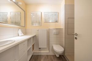 a bathroom with a toilet and a sink and a shower at fewo1846 Intermar - Gruene Insel - Studioapartment mit Balkon und Blick ins Grüne in Glücksburg +12 photos