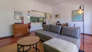 a living room with a couch and a table and a kitchen at Seaside Getaway With Balcony by LovelyStay in Almada