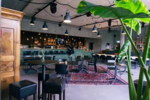 a restaurant with tables and chairs and a bar at Story Thusis in Thusis
