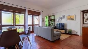 a living room with a couch and a table at Seaside Getaway With Balcony by LovelyStay in Almada