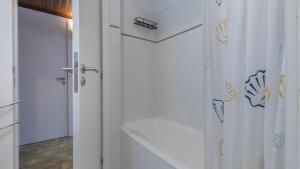 a bathroom with a shower with a white shower curtain at Seaside Getaway With Balcony by LovelyStay in Almada +22 photos