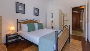 a bedroom with a large bed with green pillows at Seaside Getaway With Balcony by LovelyStay in Almada