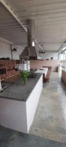 a large kitchen with a counter in a building at Chácara Harmonia Pouso Alegre in Pouso Alegre