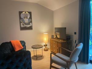 a living room with a couch and a television at De Zeeuwse Tobbe in 's-Heerenhoek