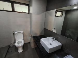 a bathroom with a white toilet and a sink at Highland Hideaway 1 Bedroom Apartment at Equatorial Hill Resort in Brinchang