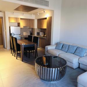 ein Wohnzimmer mit Couch und Tisch und eine Küche in der Unterkunft Nayah Stays, Luxurious bedroom in Fanadir Marina in Hurghada + 16 Fotos