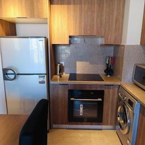 eine kleine Küche mit Kühlschrank und Geschirrspüler in der Unterkunft Nayah Stays, Luxurious bedroom in Fanadir Marina in Hurghada