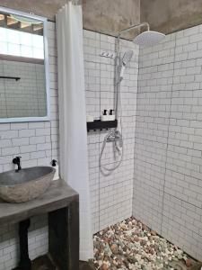 Un baño con lavabo y ducha con cortina de ducha. en InN House Homestay, en Dadapan 48 fotos más