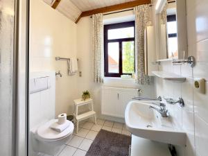 a bathroom with a sink and a toilet and a window at FeWo Kajüte 10 - Carolinensiel in Carolinensiel +14 photos