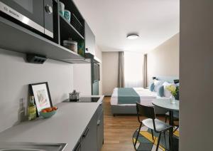 a kitchen and living room with a bed and a table at Living Hotel am Deutschen Museum in Munich
