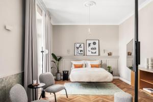 una camera bianca con un letto e due sedie di Noel Suites a Gerusalemme