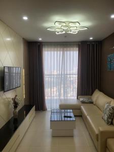 a living room with a couch and a large window at Happy Apartment-SHP Plaza Lạch Tray in Hai Phong