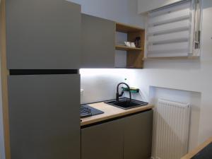 a small kitchen with a sink and a refrigerator at Appartamento Nicole in Ravascletto +37 photos
