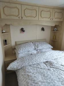 a bedroom with a bed with a white comforter at Ingoldmells Skegness holiday break at coral beach by Hannah in Lincolnshire