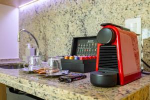 a red toaster sitting on top of a kitchen counter at Cullinan Brasilia - Fabuloso apartamento da REDE PREMIUM 05 in Brasilia