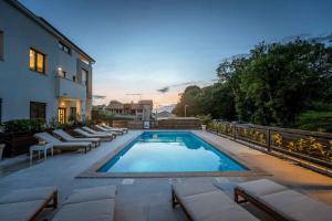 une piscine avec des chaises longues à côté d'un bâtiment dans l'établissement Apartments in Funtana - Istrien 47116, à Funtana 13 autres photos