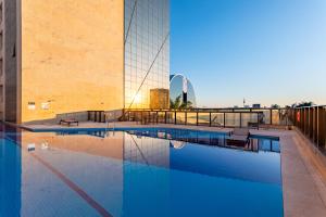 a large swimming pool next to a building at Cullinan Brasilia - Fabuloso apartamento da REDE PREMIUM 05 in Brasilia