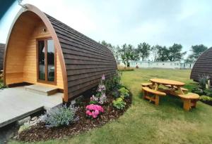 a small cabin with a table and a bench at Findhorn Ecovillage Escape Eco Pod Pet free in Findhorn