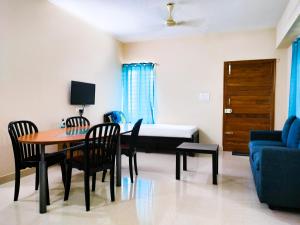 un salon avec un lit, une table et des chaises dans l'établissement Primera Extended Stay Apartments, à Bangalore