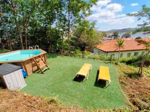 une cour avec une piscine et deux bancs jaunes dans l'établissement Apartamento 2 playa Riberuca Suances, à Suances