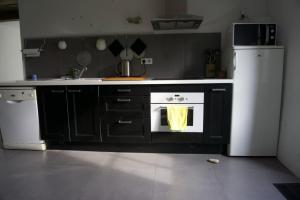 a kitchen with a stove and a white refrigerator at Maison Le Quéric La trinité sur mer in La Trinité-sur-Mer