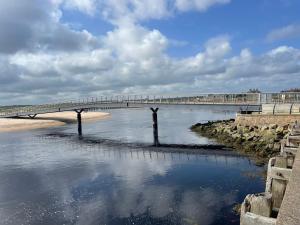 a bridge over a body of water next to a beach at Modern One Bedroom Apartment in Lossiemouth