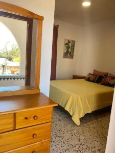 a bedroom with a bed and a dresser and a window at villa eloisa in Chiclana de la Frontera +19 photos