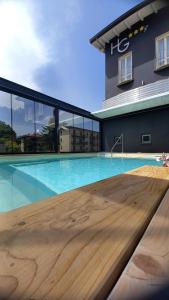 a large swimming pool with a wooden table in front of a building at Hotel Giardino in Bibbiena
