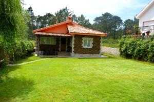 a small house with an orange roof on a yard at Casa de la playa Finisterre in Finisterre