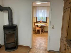 a kitchen with a stove in a room with a table at Landhof Lindner in Lüptitz