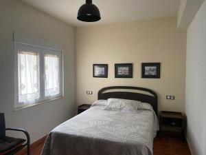 a bedroom with a bed and three pictures on the wall at Casa de la playa Finisterre in Finisterre