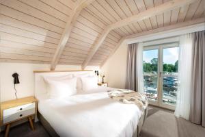 赖因斯贝格Precise Resort Marina Wolfsbruch - Familienapartments的卧室里有一张白色的大床和一扇窗户