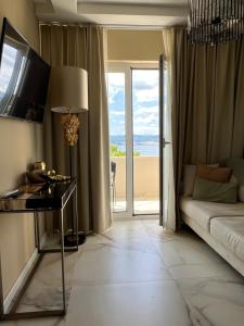 a living room with a couch and a view of the beach at LIZA I Sea View in Lokva Rogoznica