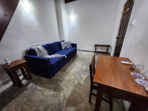a living room with a blue couch and a table at Zee Golf Affordable Luxury in Galle +23 photos