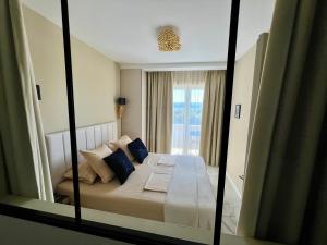 a reflection of a bedroom with a bed with blue pillows at LIZA I Sea View in Lokva Rogoznica
