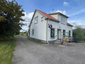 a white building with a shop on the side of it at Countryside Apartment with optional Meals in Åseda
