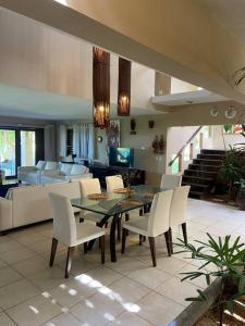 a dining table and chairs in a living room at Casa dos Coqueiros Pipa-Sibauma in Sibauma