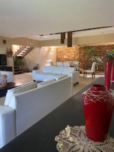 a living room with white furniture and a red vase on a table at Casa dos Coqueiros Pipa-Sibauma in Sibauma +57 photos