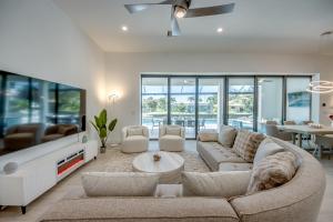 a living room with a couch and a table at BRANDNEW Villa-PureSun at Canal intersection, heated saltwater pool and spa, facing south in Cape Coral