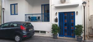 un'auto parcheggiata davanti a una casa con una porta blu di Serenity apartment ad Agia Galini