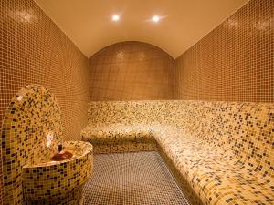 a bath room with a tub in a tiled room at Park Hotel Asenevtsi in Veliko Tŭrnovo