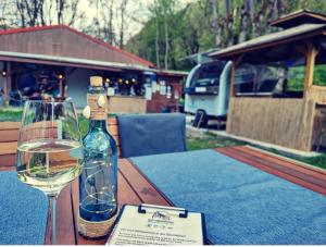 a bottle of wine and a glass on a table at Fasshotel Westernwagen, beheizt 2-3 Personen in Kirchensittenbach