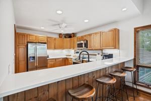 a kitchen with wooden cabinets and bar stools at Wycham Place in Boone