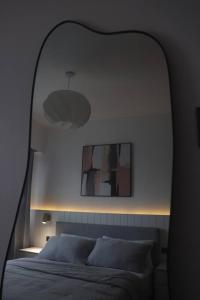 a bedroom with a bed with a mirror above it at Modern Nordic 1 Bedroom Condo near Eastwood, Quezon City in Manila