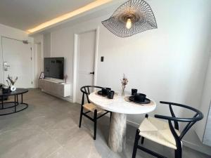 a living room with a table and chairs and a television at Modern Nordic 1 Bedroom Condo near Eastwood, Quezon City in Manila +19 photos