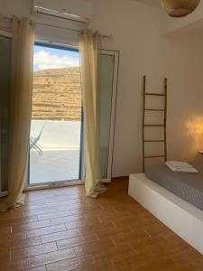 a bedroom with a bed and a sliding glass door at Sofianna's oasis in Kalloni Tinou