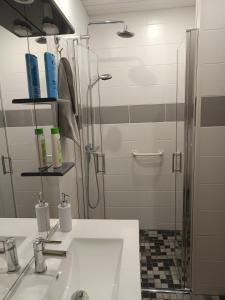 Un baño blanco con lavabo y ducha. en LA CLIMONTAINE BIS, en Urbeis 12 fotos más