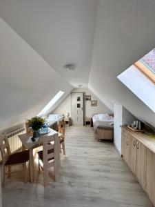 a attic room with a table and a bed at Dom Gościnny Stokrotka in Pustkowo